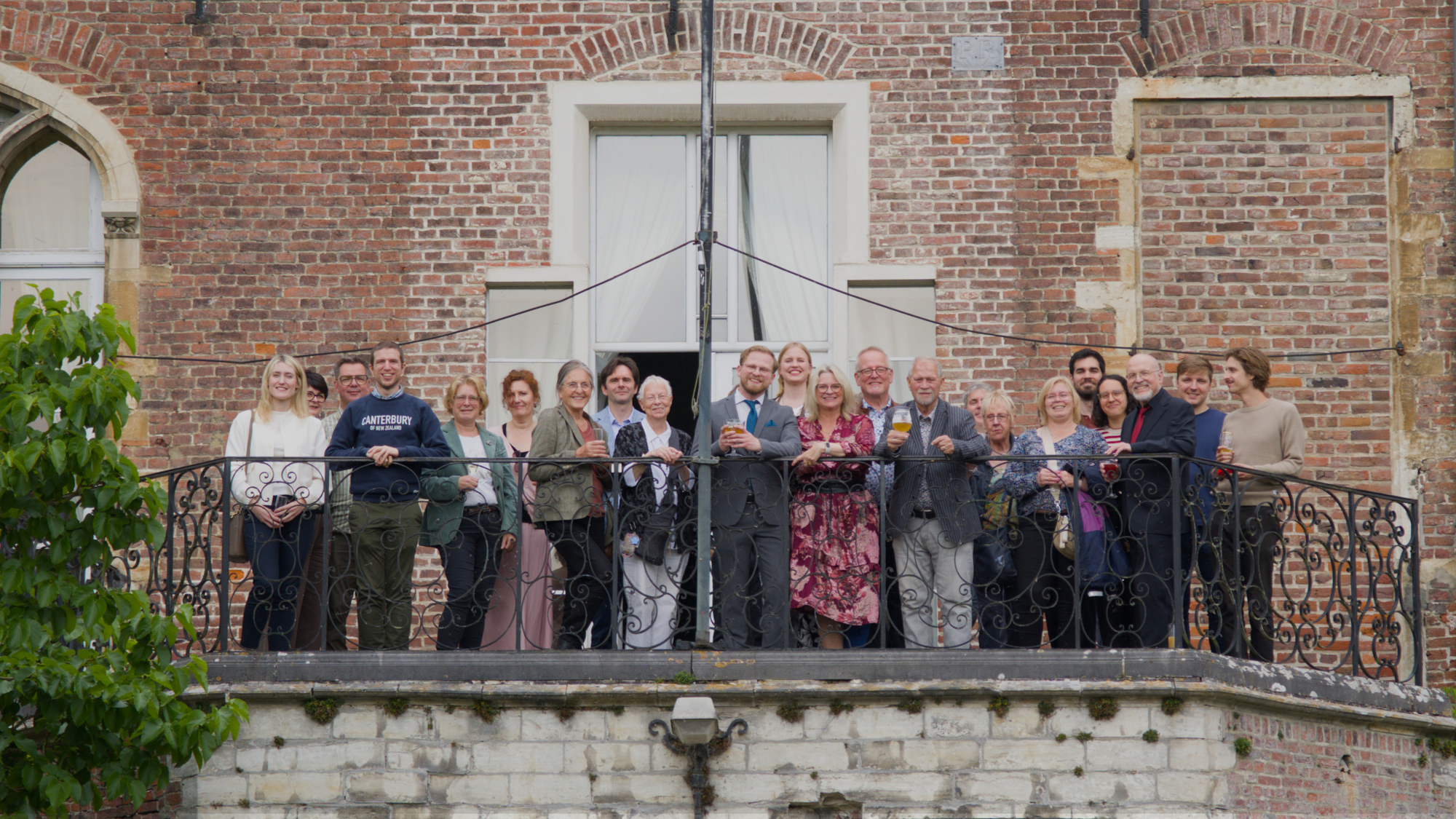 A group photo of all guests on the balcony of the castle.